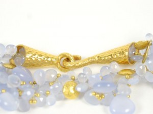 A close up of some gold jewelry with blue stones