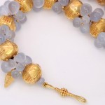 A close up of the necklace with gold beads