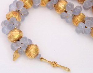 A close up of the necklace with gold beads