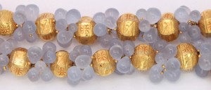 A close up of some gold beads and blue buttons