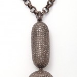 A long necklace with a large pendant and small chain.