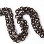 A chain link necklace is shown on top of a white background.