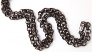 A chain link necklace is shown on top of a white background.