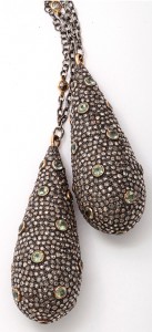 A pair of earrings with green stones on them.