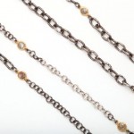 A close up of three chains with different types of stones.