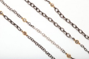 A close up of three chains with different types of stones.