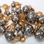 A close up of a necklace with gold and black beads