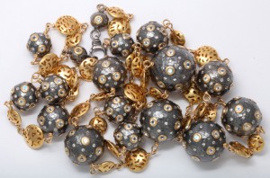 A close up of a necklace with gold and black beads