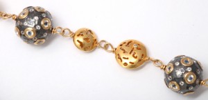 A close up of the gold chain with two balls