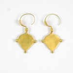 A pair of gold earrings with some shapes and lines