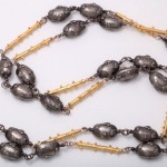 A long necklace with gold and silver beads.