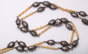 A long necklace with gold and silver beads.