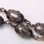 A close up of the chain of an antique necklace