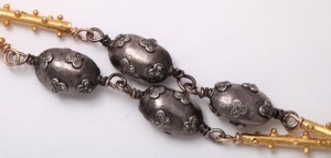 A close up of the chain of an antique necklace