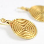 A pair of gold earrings with spirals and stars.