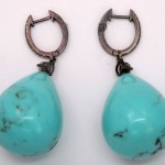 A pair of turquoise earrings with black patina.