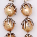 A pair of gold and diamond earrings with pearls.