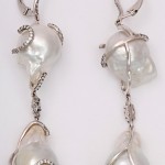 A pair of long pearl and diamond earrings.