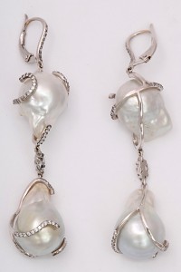 A pair of long pearl and diamond earrings.