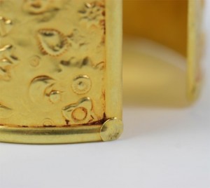 A close up of the side of a gold bracelet