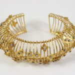 A gold bracelet with lots of small flowers.