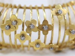A close up of the gold bracelet with flowers