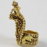 A gold ring with an elephant and bird on it.