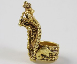 A gold ring with an elephant and bird on it.