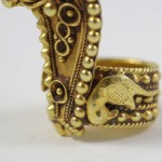 A close up of the side of an ornate gold ring