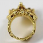 A gold ring with a crown on it's side.