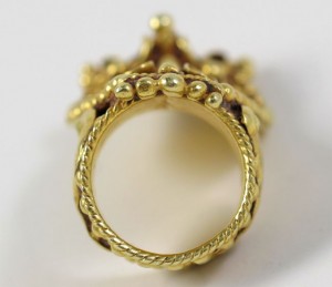 A gold ring with a crown on it's side.