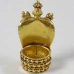 A gold crown shaped trinket box with a lid.