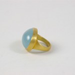 A gold ring with a blue stone on top of it.