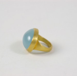 A gold ring with a blue stone on top of it.