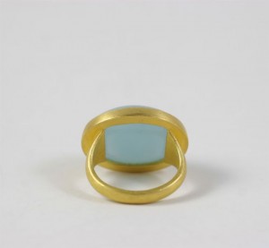 A gold ring with a blue stone on top of it.