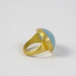 A gold ring with a blue stone on top of it.