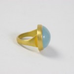 A gold ring with a blue stone on top of it.