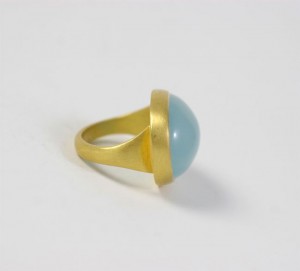 A gold ring with a blue stone on top of it.