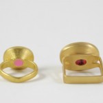 Two gold rings with one pink stone and the other a yellow.