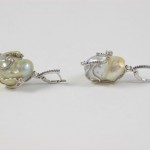 A pair of earrings with pearls and silver wire.