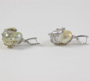 A pair of earrings with pearls and silver wire.