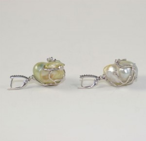 A pair of earrings with pearls and silver.