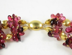 A close up of the necklace with red beads