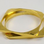 A gold ring with two intersecting sections on top of it.