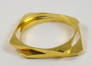 A gold ring with two intersecting sections on top of it.