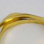 A close up of the side of two gold bracelets