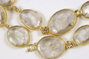 A close up of some gold jewelry with clear stones
