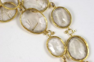 A close up of some gold jewelry with clear stones