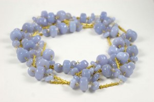 A necklace of blue beads and gold chains.