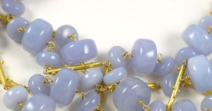 A close up of some blue beads on a white surface